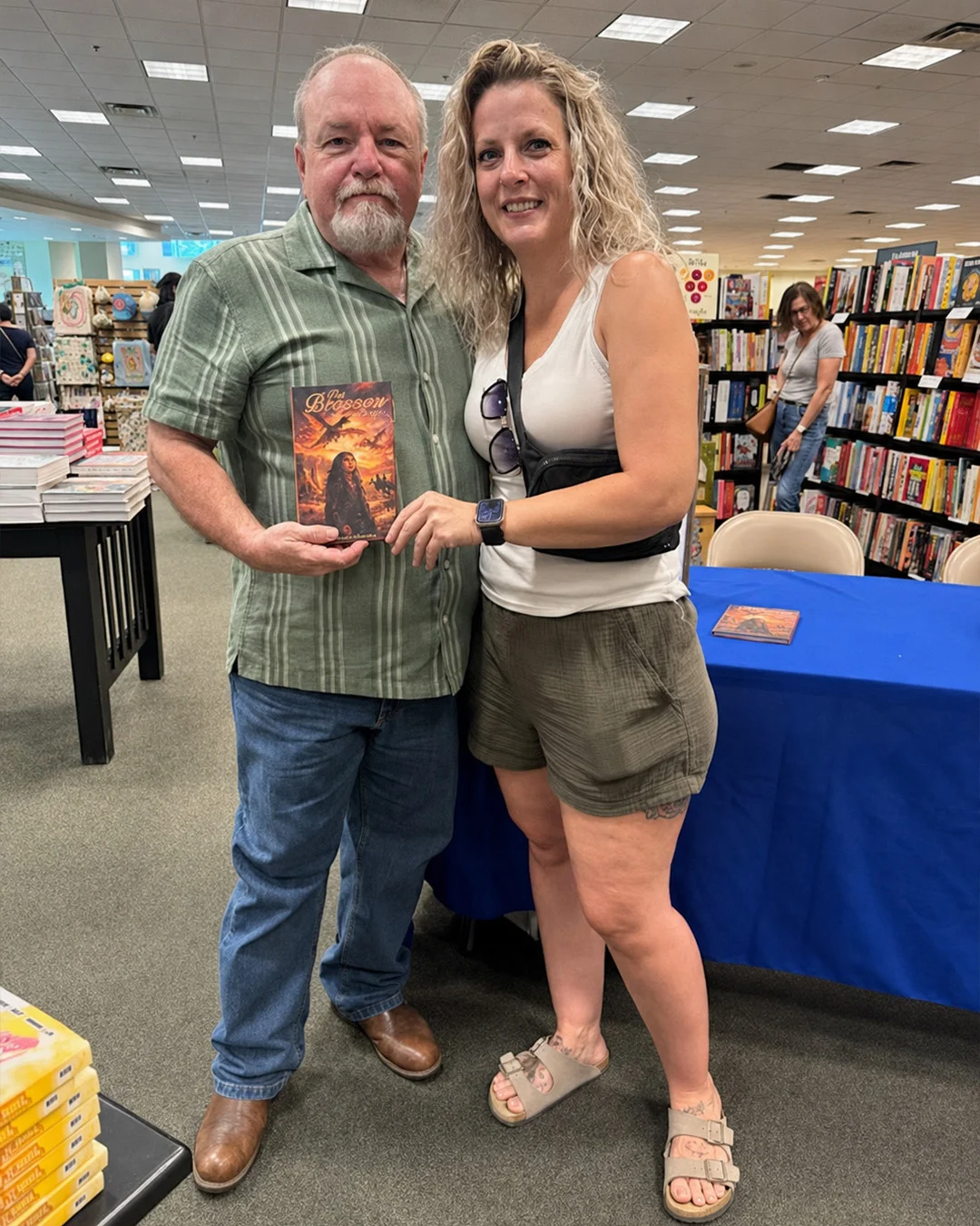 An author standing beside a reader who is holding the copy he has just signed for her